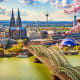 Cologne Cathedral and Hohenzollern Bridge spanning the Rhine River with spring blossoms in foreground